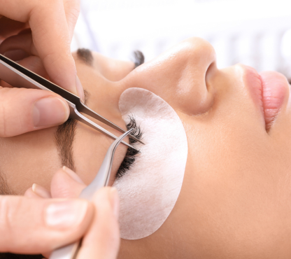 A woman at Melody Salon is getting her eyelashes trimmed with scissors, reflecting the salon's expertise in various beauty services.